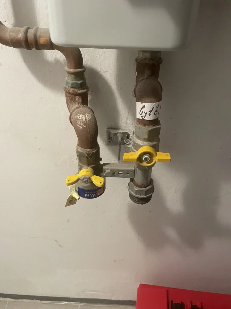 Plynové ventily se žlutými páčkami na potrubí