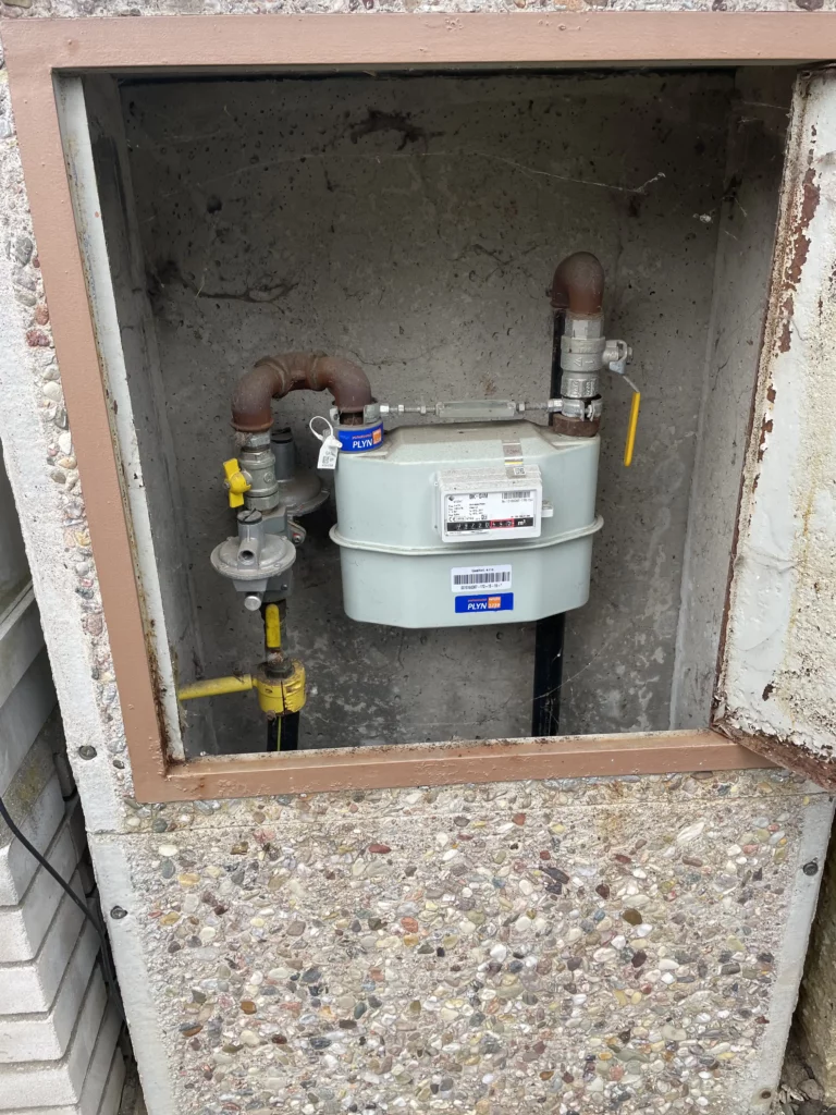 Plynoměr zabudovaný do zdi v kovovém boxu