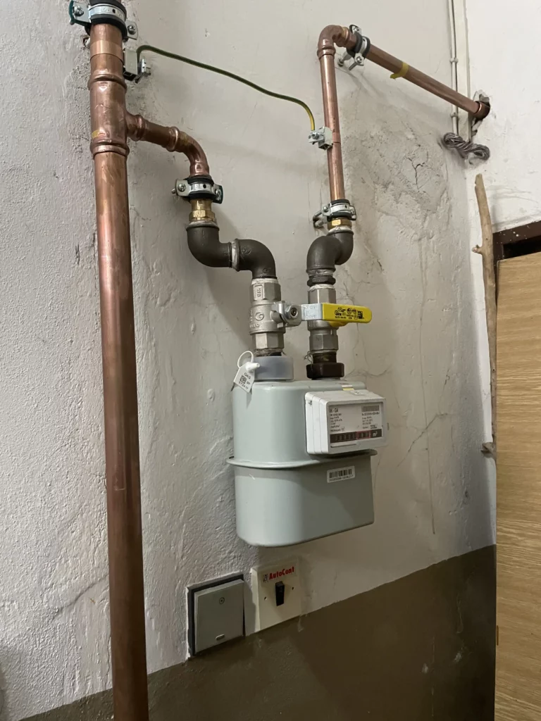 Plynoměr s měděnými rozvody plynu na zdi