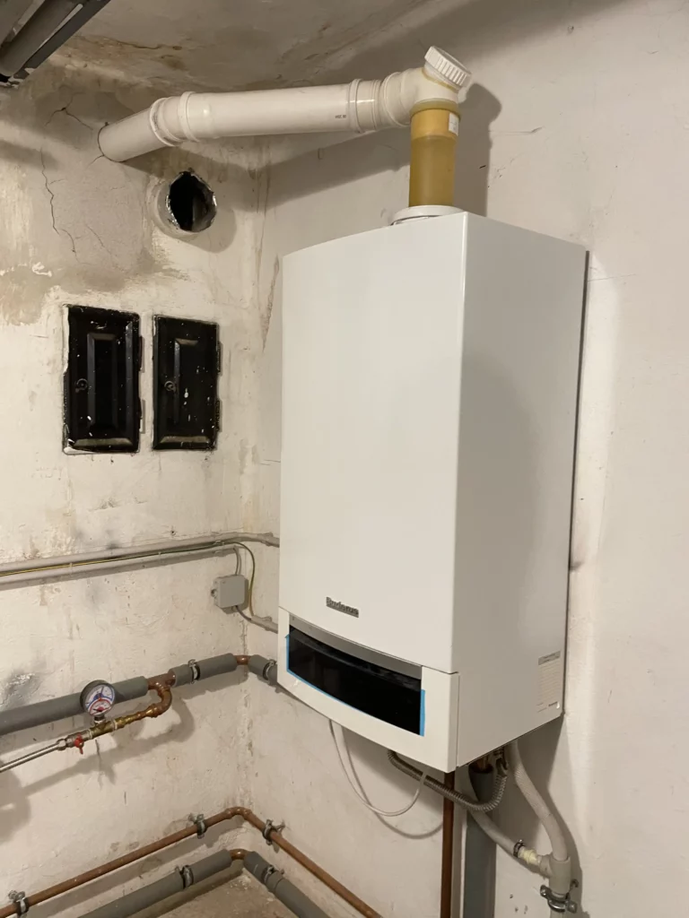 Bílý nástěnný plynový kotel instalovaný na zdi