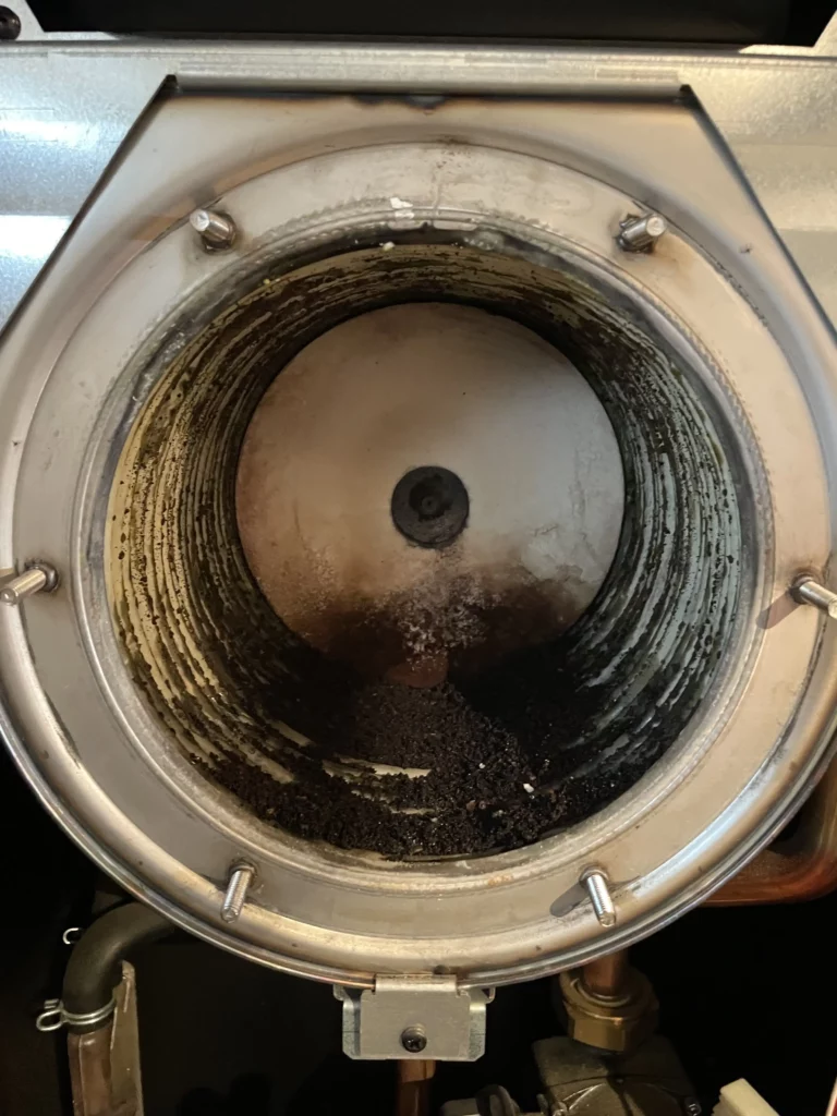 Detail hořáku plynového kotle se stopami používání