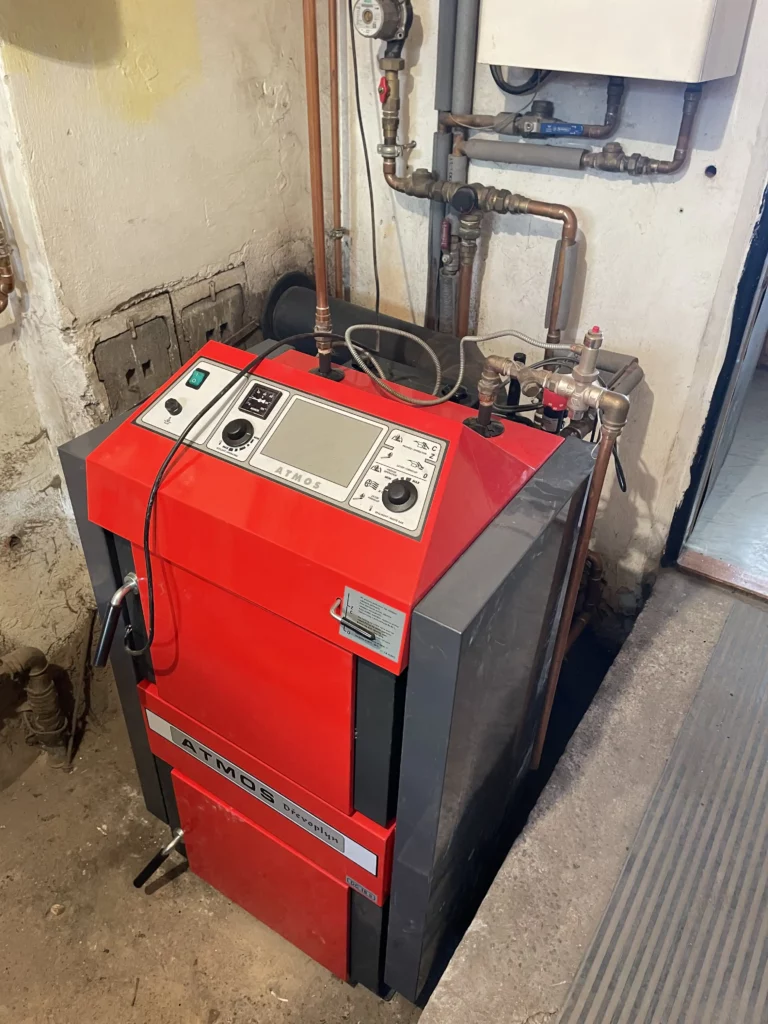 Červený kotel v kotelně se zapojeným potrubím